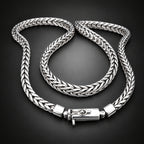 Silver braided bracelet on a wooden surface with a dark background