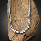 Silver braided necklace on a wooden surface