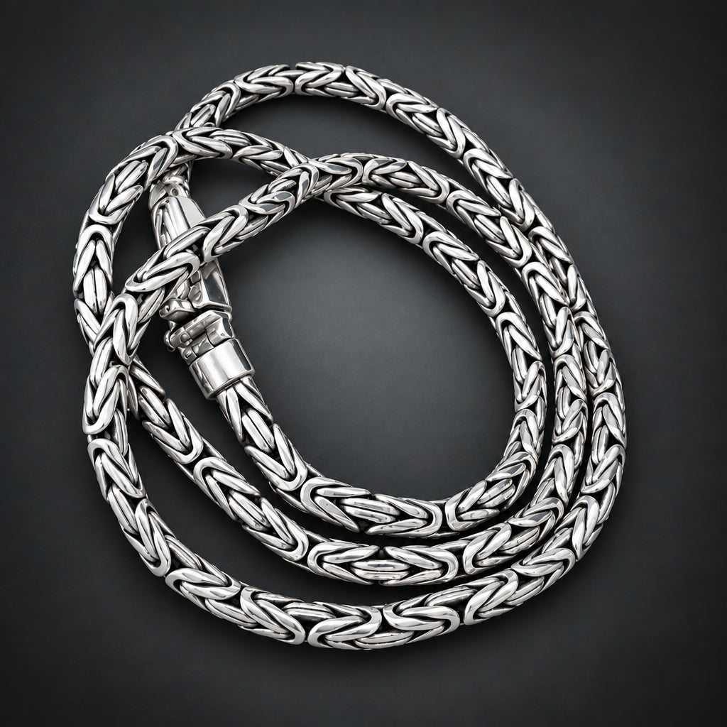 Silver braided necklace on a hand with a wooden background