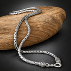 Silver braided necklace on a wooden surface