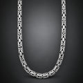 A close-up studio shot of a silver-toned chain necklace with repeating geometric interlocking links, arranged in a U-shape against a dark gray gradient background.