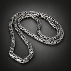 Silver braided necklace on a dark background