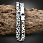 Silver bracelet with intricate design on a wooden surface