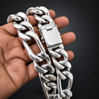 A close-up of a hand holding a thick, polished silver Cuban link chain bracelet against a solid black background.