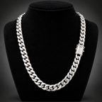 A thick silver Cuban link chain necklace displayed on a black velvet jewelry bust against a dark background.