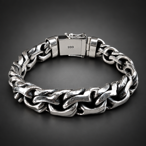 A chunky silver-tone steel chain bracelet with a clasp stamped '999', displayed on a rustic dark wood background.