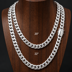 Two silver Cuban link necklaces displayed on a dark brown wooden mannequin bust against a black background, labeled 20 inches and 22 inches.