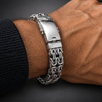 Silver bracelet on a wrist against a wooden background
