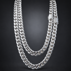 A double-strand silver Cuban link chain necklace with a polished rectangular clasp, displayed against a dark gray gradient background.